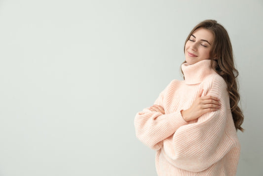 Woman looking content in fuzzy, oversized pink sweater